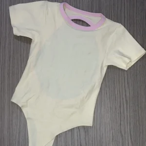 Body manga corta marfil con sesgo rosa — Velora Essentials en Jamundí